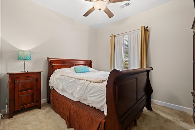 bedroom with baseboards, ceiling fan, visible vents, and light colored carpet