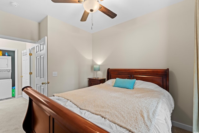 carpeted bedroom featuring stacked washer and dryer, ceiling fan, and baseboards