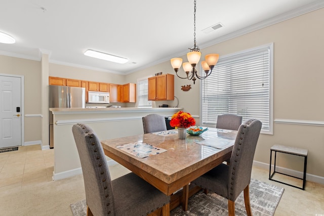 dining room featuring ornamental molding, light carpet, baseboards, and an inviting chandelier