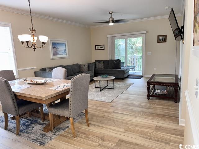 6253 Catalina Dr Unit 921, North Myrtle Beach, SC 29582 - dining space with light wood-type flooring, a chandelier, ceiling fan, crown molding, and baseboards