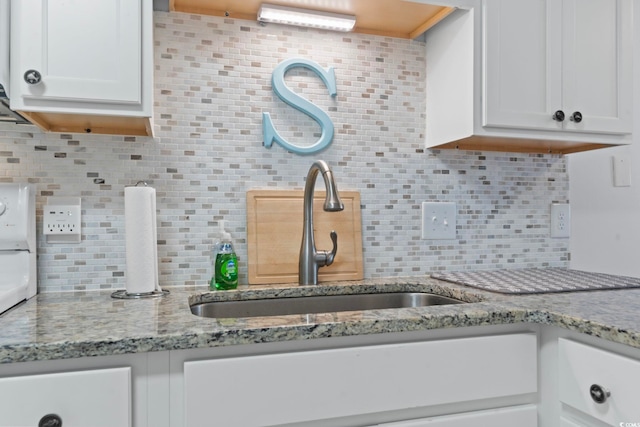 kitchen with light stone counters, white cabinets, and decorative backsplash