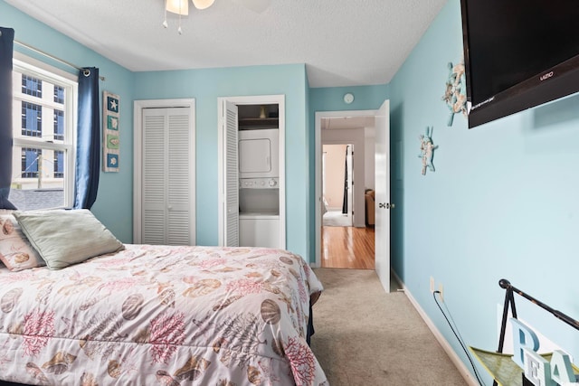 carpeted bedroom with a textured ceiling, ceiling fan, and baseboards