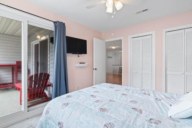 bedroom featuring a ceiling fan, visible vents, and multiple closets