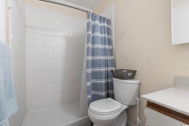 bathroom with tiled shower, vanity, and toilet