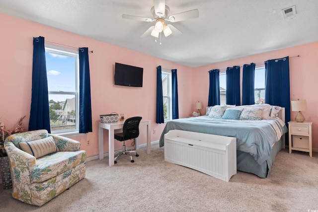 bedroom with ceiling fan, baseboards, visible vents, and light colored carpet