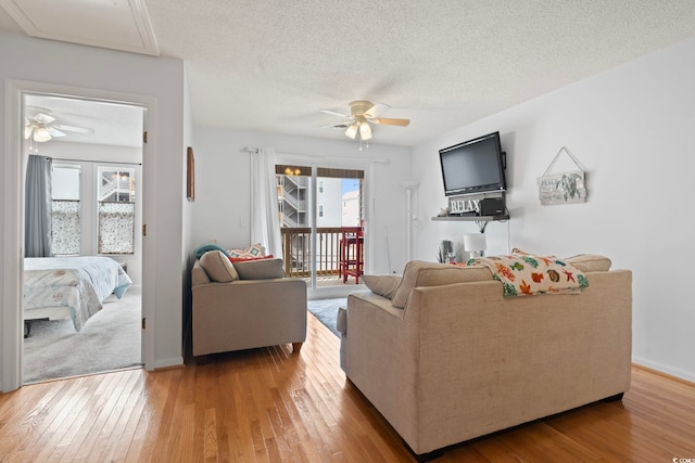 living area with plenty of natural light, light wood-style flooring, and ceiling fan