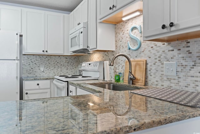 kitchen featuring white appliances, white cabinetry, and a sink