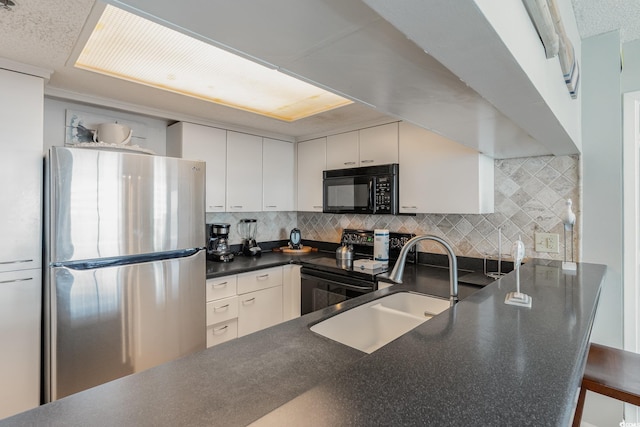 9820 Queensway Blvd Unit 301, Myrtle Beach, SC 29572 - kitchen featuring black appliances, dark countertops, tasteful backsplash, white cabinets, and a peninsula