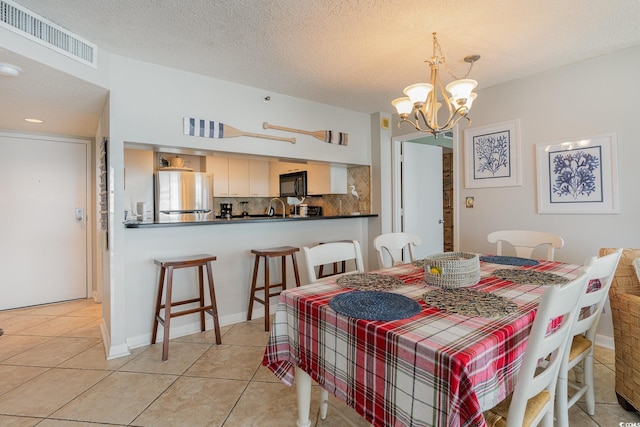 9820 Queensway Blvd Unit 301, Myrtle Beach, SC 29572 - dining space featuring a chandelier, light tile patterned flooring, and a textured ceiling
