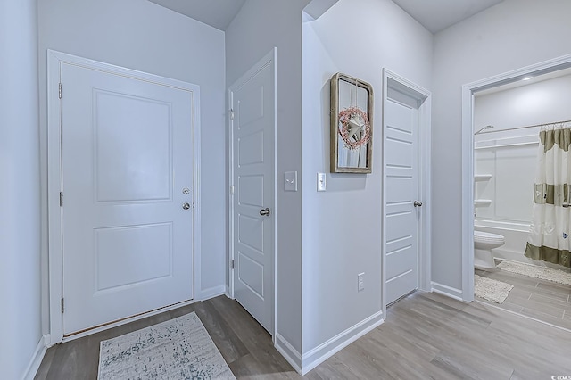 entryway with wood finished floors and baseboards