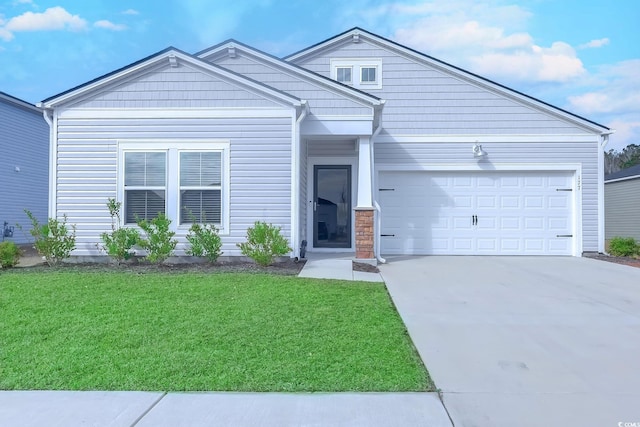 view of front of property with a front yard, concrete driveway, and an attached garage