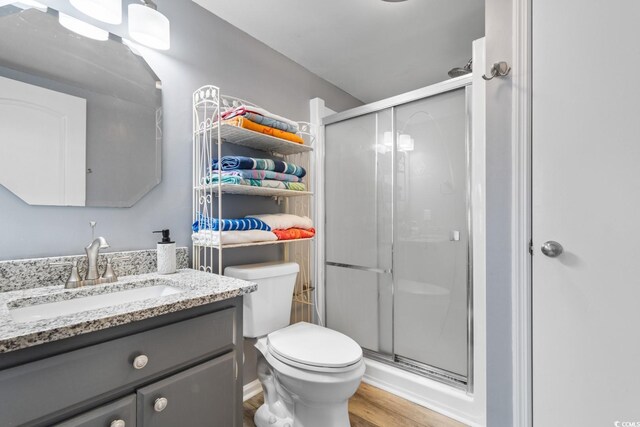 3308 S Ocean Blvd Unit 2-A, North Myrtle Beach, SC 29582 - full bathroom with vanity, a shower stall, wood finished floors, and toilet