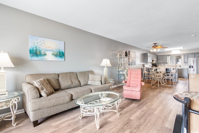 3308 S Ocean Blvd Unit 2-A, North Myrtle Beach, SC 29582 - living room featuring light wood-type flooring, a ceiling fan, baseboards, and a textured ceiling
