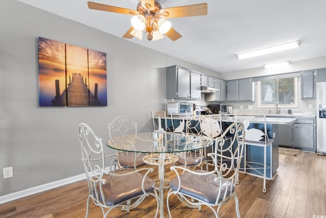 3308 S Ocean Blvd Unit 2-A, North Myrtle Beach, SC 29582 - dining area with light wood finished floors, a ceiling fan, and baseboards