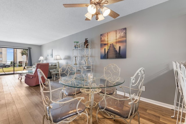 3308 S Ocean Blvd Unit 2-A, North Myrtle Beach, SC 29582 - dining area with wood finished floors, a ceiling fan, a textured ceiling, and baseboards