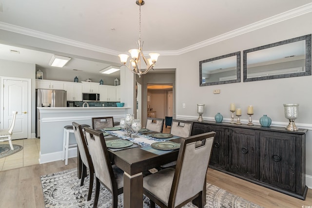 dining space with crown molding, light wood-type flooring, and an inviting chandelier