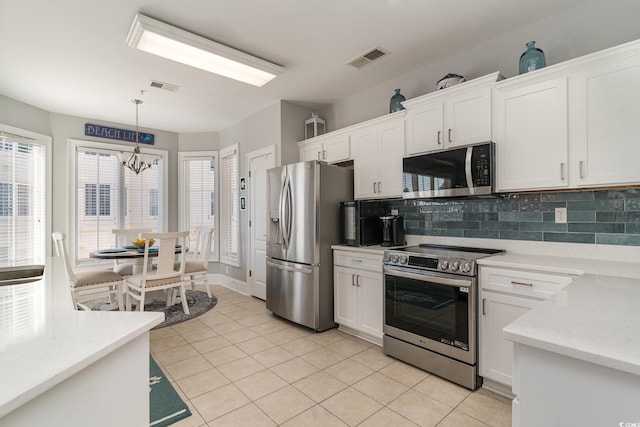 kitchen with white cabinets, appliances with stainless steel finishes, visible vents, and decorative backsplash