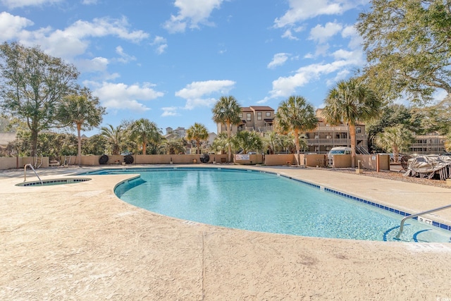 pool with a community hot tub, a patio area, and fence