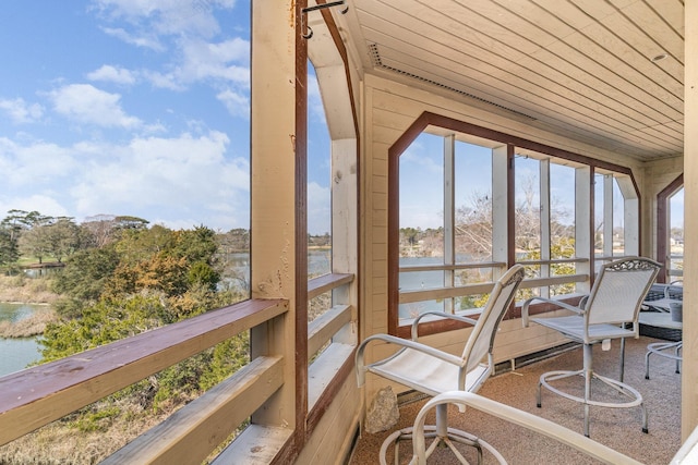 sunroom featuring a water view and wood ceiling