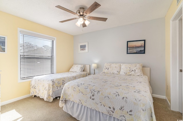 bedroom featuring a textured ceiling, carpet flooring, a ceiling fan, and baseboards