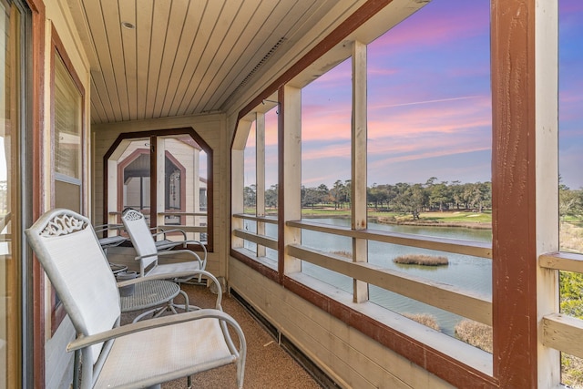 sunroom / solarium with wooden ceiling and a water view