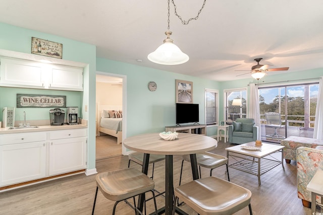 dining area with ceiling fan, baseboards, and light wood-style floors