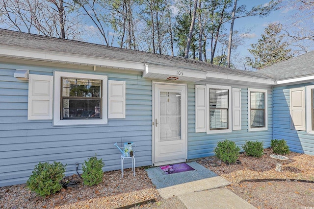 property entrance with roof with shingles