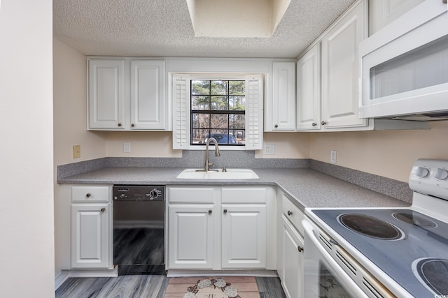 kitchen with white cabinets, a sink, a textured ceiling, wood finished floors, and white appliances