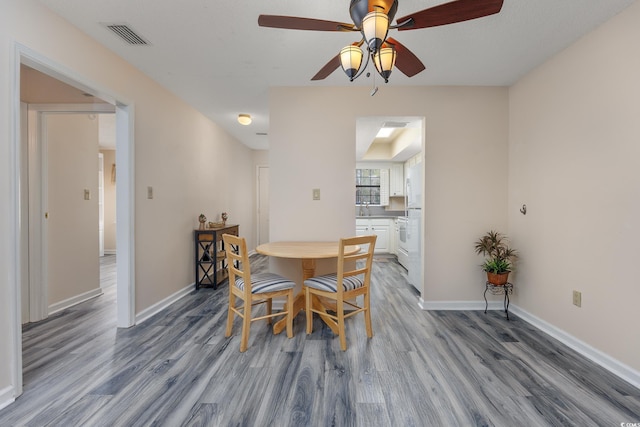 dining space with visible vents, baseboards, and wood finished floors