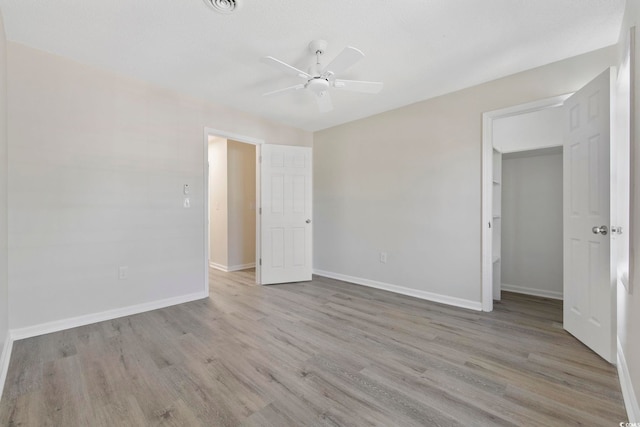 empty room featuring ceiling fan, baseboards, and wood finished floors