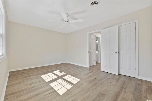 unfurnished bedroom with ceiling fan, wood finished floors, visible vents, and baseboards