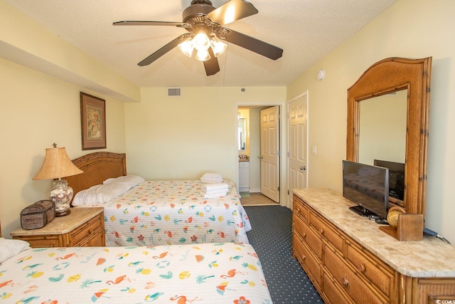 bedroom featuring a textured ceiling, dark colored carpet, visible vents, and a ceiling fan