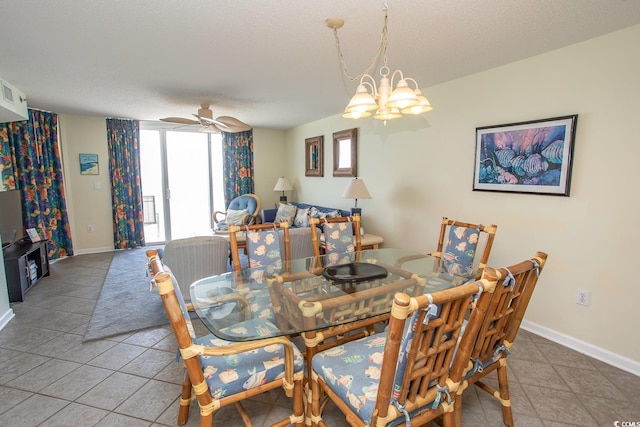 tiled dining area featuring a textured ceiling, baseboards, and ceiling fan with notable chandelier