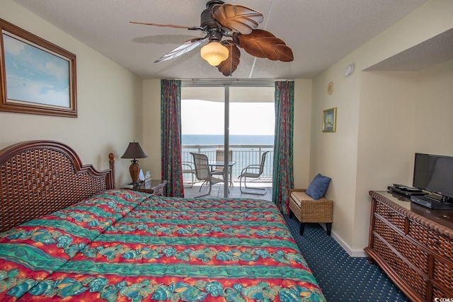 bedroom featuring carpet, ceiling fan, a textured ceiling, a wall of windows, and access to outside