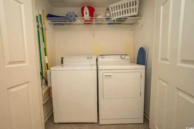 laundry room featuring laundry area, washer and clothes dryer, and light tile patterned flooring