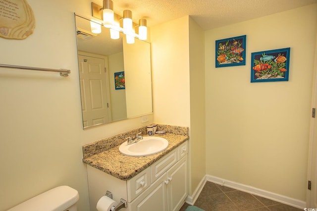 half bathroom featuring visible vents, toilet, tile patterned flooring, a textured ceiling, and vanity