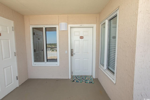 entrance to property featuring stucco siding