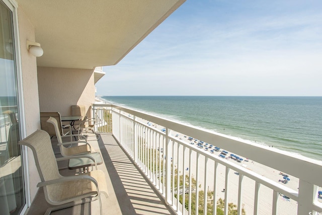 balcony featuring a view of the beach and a water view