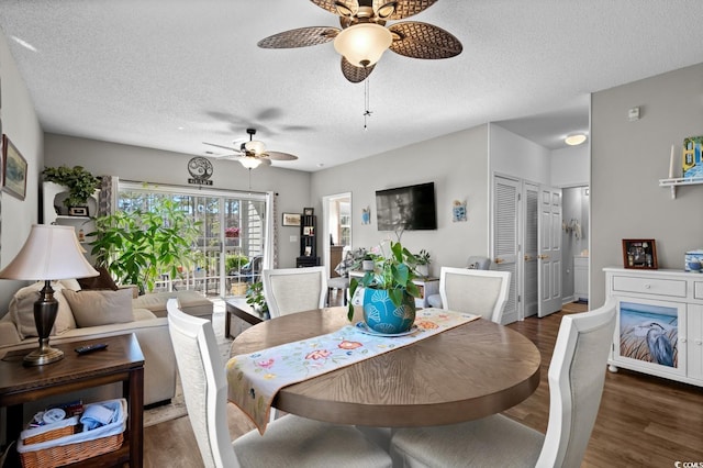 dining area featuring a textured ceiling and wood finished floors