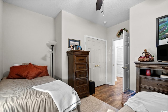 bedroom featuring dark wood-style flooring, ceiling fan, and a textured ceiling