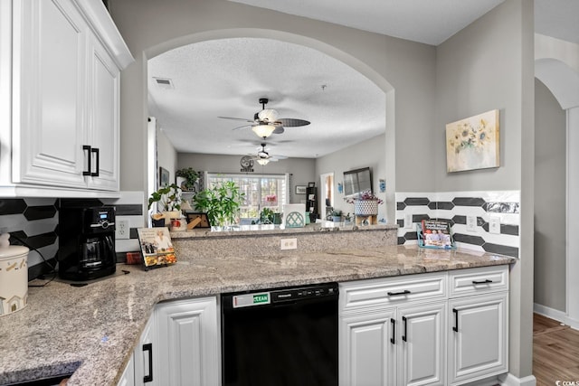 kitchen with dishwasher, a textured ceiling, visible vents, and white cabinets