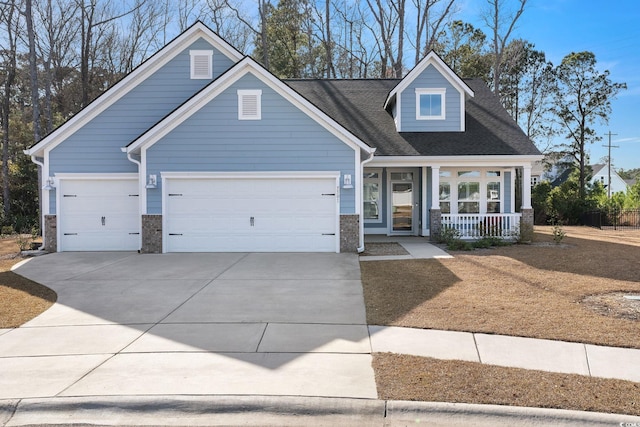 view of front of property with a garage, concrete driveway, and covered porch