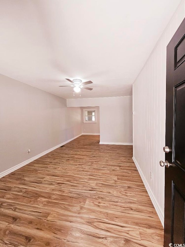 unfurnished room featuring ceiling fan, light wood-type flooring, and baseboards