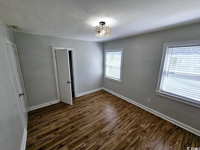 unfurnished bedroom with dark wood-style floors and baseboards