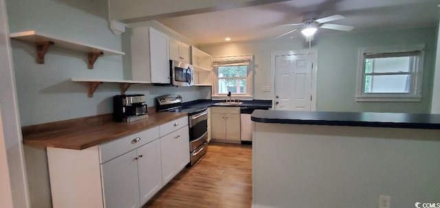 kitchen featuring open shelves, appliances with stainless steel finishes, a sink, and white cabinets