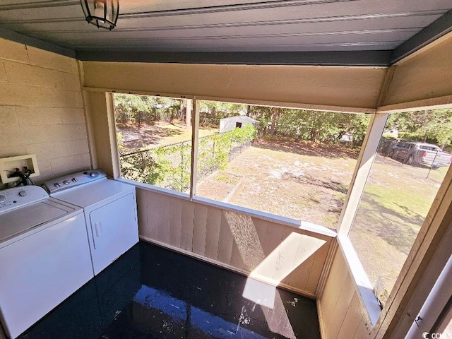 laundry room with concrete block wall and independent washer and dryer