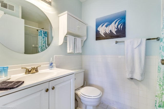 bathroom featuring curtained shower, toilet, vanity, visible vents, and tile walls