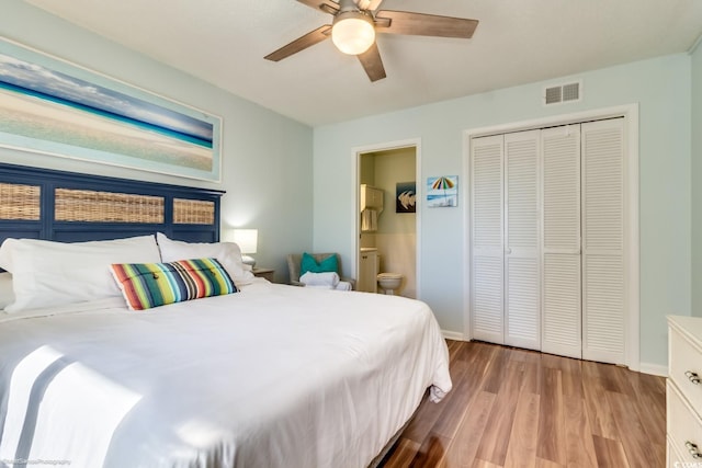 bedroom with ensuite bathroom, ceiling fan, wood finished floors, visible vents, and baseboards