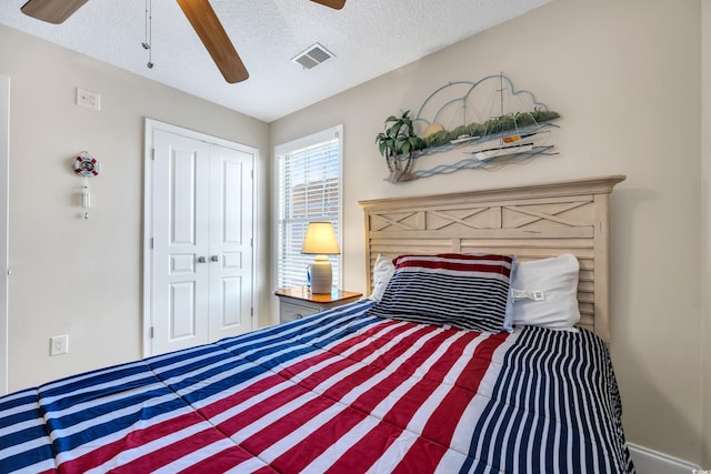 bedroom with a ceiling fan, a closet, visible vents, and a textured ceiling