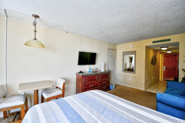 bedroom featuring carpet, visible vents, and a textured ceiling